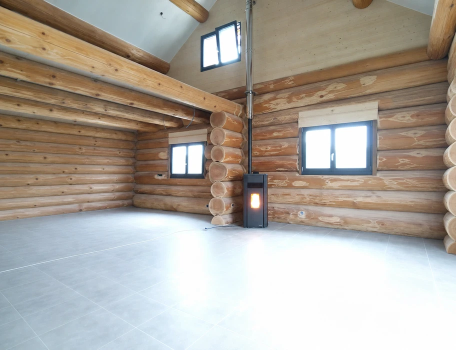 Intérieur vide d'un chalet en rondins de bois naturel, sol en carrelage gris clair