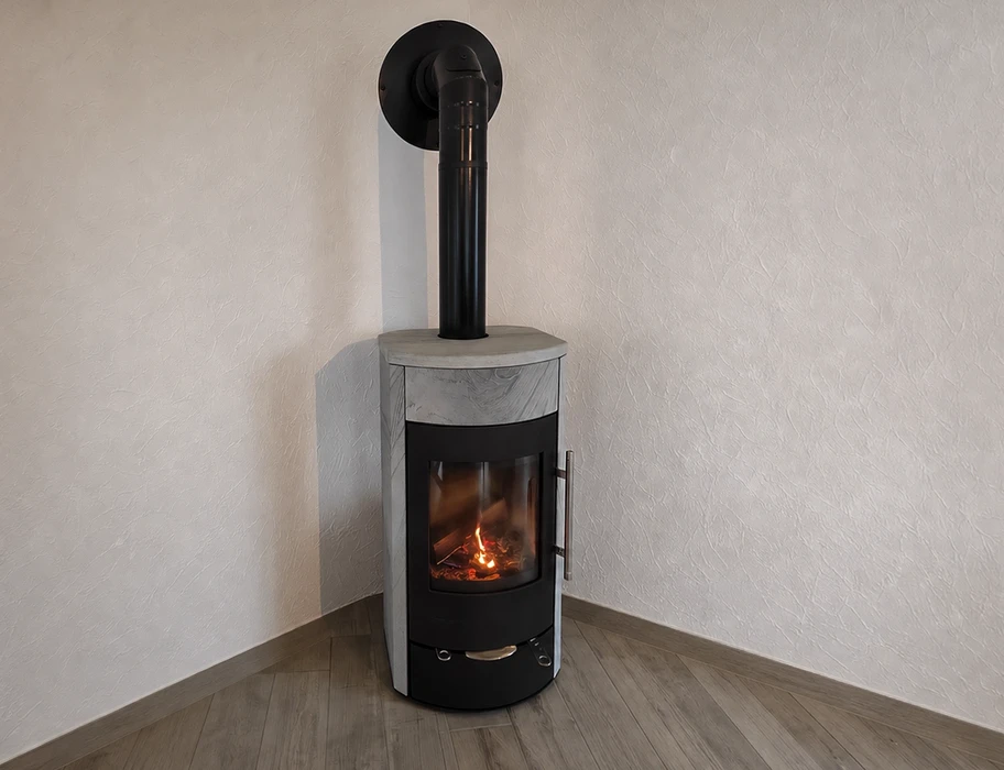 Poêle à bois cylindrique moderne installé en angle, en fonctionnement